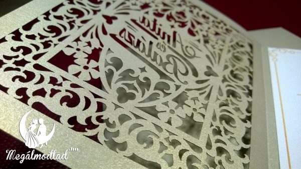 Egyedi esküvői meghívó sűrű romantikus indás mintával, az ifjú pár nevével a középpontban.
